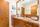 Large wood-paneled vanity cabinet and granite vanity top in guest bathroom